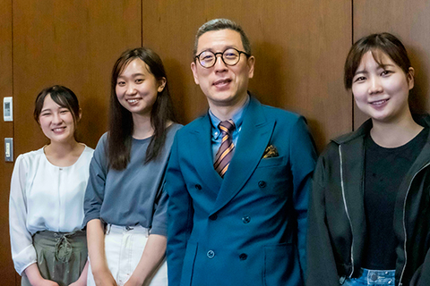 向韓校長(照片右邊)微笑著報告獲獎的足立老師(照片左邊)