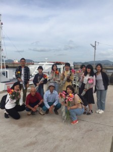 拿著收到的六連島的花和自治會的各位一起